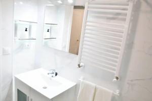 a white bathroom with a sink and a mirror at Nuevo apartamento de 3 dormitorios en calle Alta in Santander