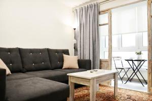 a living room with a black couch and a table at Nuevo apartamento de 3 dormitorios en calle Alta in Santander