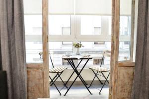 a table and chairs in a room with windows at Nuevo apartamento de 3 dormitorios en calle Alta in Santander +28 photos