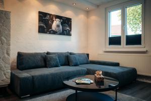 a living room with a blue couch and a table at Ferienappartement im Thüringer Wald in Bad Salzungen