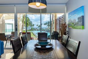 プラヤ・デル・カルメンにあるThe Elements Oceanfront & Beachside Condo Hotelのダイニングルーム(テーブル付)が備わり、プールの景色を望めます。