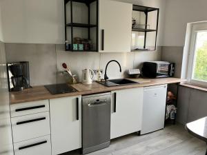 a kitchen with white cabinets and a counter top at Duży komfortowy apartament in Grajewo