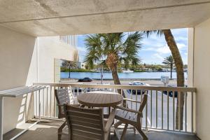 a table and chairs on a balcony with a view of the water at Fifty Gulfside Condominiums in Clearwater Beach