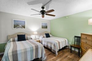 a bedroom with two beds and a ceiling fan at Fifty Gulfside Condominiums in Clearwater Beach