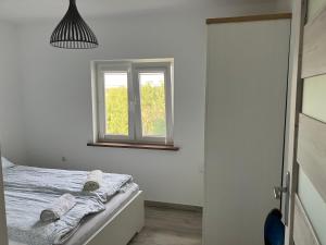 a white bedroom with a bed with towels on it at Duży komfortowy apartament in Grajewo