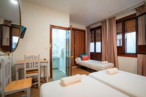 a room with two beds and a desk and a mirror at Veronica Centro in Granada