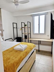 a bedroom with a bed and a desk and a window at Genial y confortable Cerca de Miraflores, Forum Majadas H11 in El Rodeo