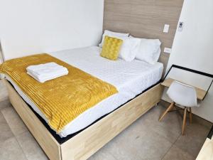 a bedroom with a bed with a yellow blanket on it at Genial y confortable Cerca de Miraflores, Forum Majadas H11 in El Rodeo