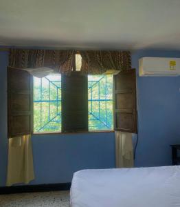 a bedroom with a window in a blue room at Hotel Villa Mary Apartaestudios playa in Puerto Colombia +13 photos