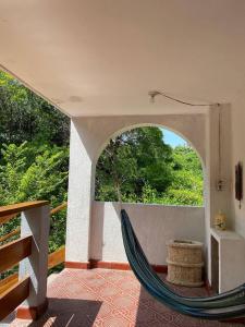 a hammock in a room with a view of trees at Hotel Villa Mary Apartaestudios playa in Puerto Colombia