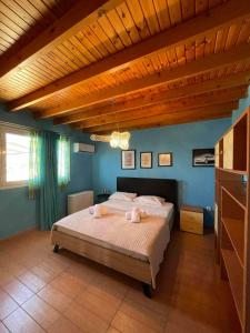 a bedroom with a large bed with a wooden ceiling at Castelo Chalet Chios in Chios
