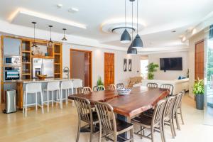 a kitchen and dining room with a wooden table and chairs at Hermosa Waves D1 in Jacó