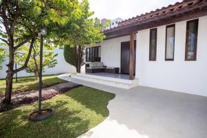 a patio of a house with a tree and grass at Casa Jardim - Praia do Bessa por Carpediem in João Pessoa