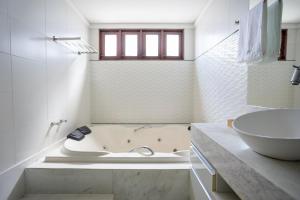 a white bathroom with a tub and a sink at Casa Jardim - Praia do Bessa por Carpediem in João Pessoa