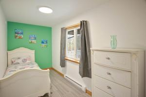 a childs bedroom with a white crib and a window at Tucked Away Walk to Beach Pet Friendly Relax in Rothesay +19 photos