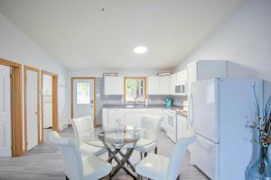 a kitchen with a glass table and white chairs at Tucked Away Walk to Beach Pet Friendly Relax in Rothesay