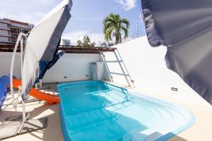 a swimming pool with a ladder and an umbrella at Casa Jardim - Praia do Bessa por Carpediem in João Pessoa +71 photos