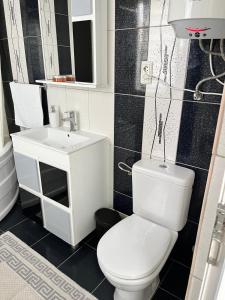 a bathroom with a white toilet and a sink at Casa Angy in Jurilovca +15 photos