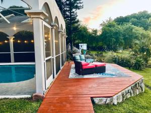 un patio con sofá en una terraza de madera junto a la piscina en Aphrodites Paradise - Near Disney World and Busch Gardens, en Auburndale