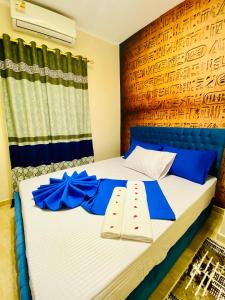 a bedroom with a bed with blue bows on it at Horus pyramids view in Cairo