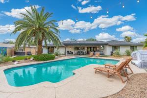 a home with a swimming pool and a palm tree at 6 Bed Luxury Heated Pool in Phoenix