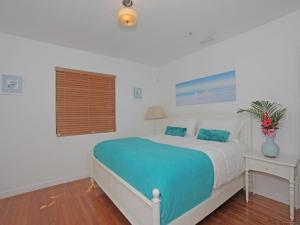1 dormitorio con 1 cama grande con almohadas azules en Bikini Lodge, en Miami Beach