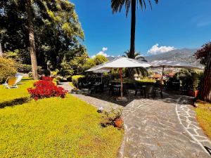 een patio met tafels en parasols in een tuin bij Eurotel 405 in Rapallo +21 foto's