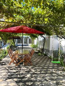 a table and chairs under an umbrella on a patio at Casa Angy in Jurilovca