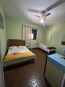 ein Schlafzimmer mit zwei Betten und einem Deckenventilator in der Unterkunft Hotel Shangri-la in Três Corações