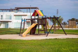 a playground with a slide in a park at Departamento Paracas vista al mar in Paracas