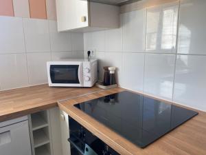 a kitchen with a microwave on a wooden counter at Appt Ô en Couleurs in Auch +7 photos