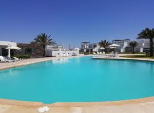 a large swimming pool with blue water in a resort at Departamento Paracas vista al mar in Paracas +8 photos