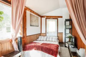 un dormitorio con una cama y una ventana en Charming Rustic Chalet on Lac Marie Louise, en Lac-Saint-Paul