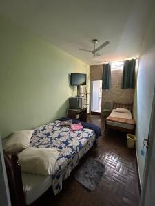 ein Schlafzimmer mit einem Bett und einem Fernseher in der Unterkunft Hotel Shangri-la in Três Corações