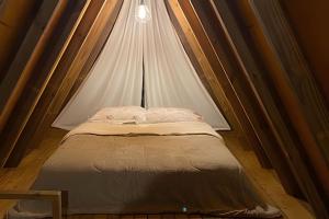 a small bed in a room with a canopy at Chalé dos Alpes 1 hidromassagem e Lareira in Santo Amaro da Imperatriz