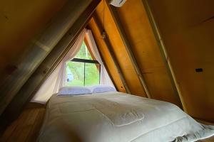 a bed in a small room with a window at Chalé dos Alpes 1 hidromassagem e Lareira in Santo Amaro da Imperatriz +29 photos