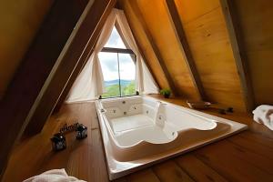 圣阿马鲁-达因佩拉特里斯Chalé dos Alpes 2 hidromassagem e Lareira的带窗户的房间里的浴缸 更多34张照片
