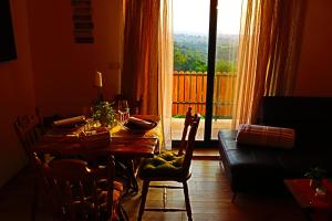 a dining room with a table and a couch and a window at Vinea holiday home in Jakopovec
