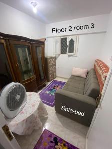 a living room with a couch and a fan at First Row Sea-Front Chalets Media Village in Marsa Matruh +30 photos