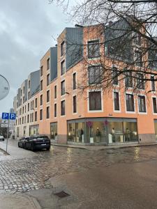 a large brick building with a car parked in front of it at Cozy Apartment in Old Riga & Free Underground Parking in Rīga