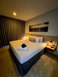 una camera da letto con un grande letto con un cappello sopra di Hotelito del Mar Playa del Carmen a Playa del Carmen