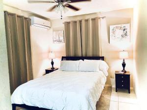 クライストチャーチにあるSeashades 2BR 1 full and 1 half bathrooms Condo with pool Close to beach Sleeps 4のベッド、ナイトスタンド2台、ランプ2個を備えた寝室 +40枚の写真