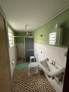 ein Badezimmer mit Toilette und Waschbecken in der Unterkunft Hotel Shangri-la in Três Corações