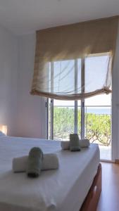 a bedroom with a white bed with a large window at SeaHomes Vacations - Seafront Apt in Blanes with PKG in Blanes +39 photos