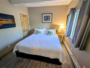 a bedroom with a bed with a white comforter at Main Street Breck, Walk Everywhere! in Breckenridge
