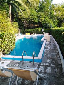 a swimming pool with two chairs and a table at La Loggia Sul Mare in Rapallo
