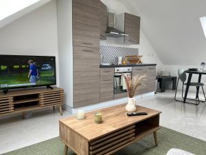 a living room with a tv and a coffee table at Appartement Chic avec Balneo in Vierzon +11 photos