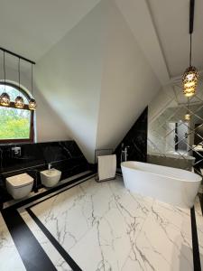 a bathroom with a white tub and two sinks at Yeti Studio Apartament Krupówki 73C in Zakopane +7 photos