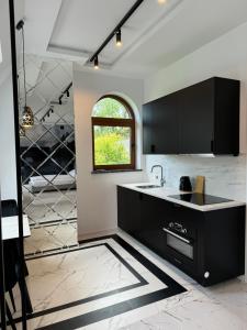 a kitchen with a black counter and a window at Yeti Studio Apartament Krupówki 73C in Zakopane