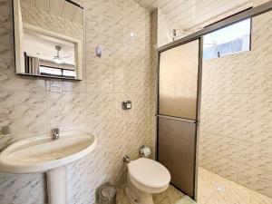 une salle de bain avec un lavabo et des toilettes dans l'établissement Apê Família, A/C e 3 Quartos | 450m Canasvieiras, à Florianópolis 9 autres photos